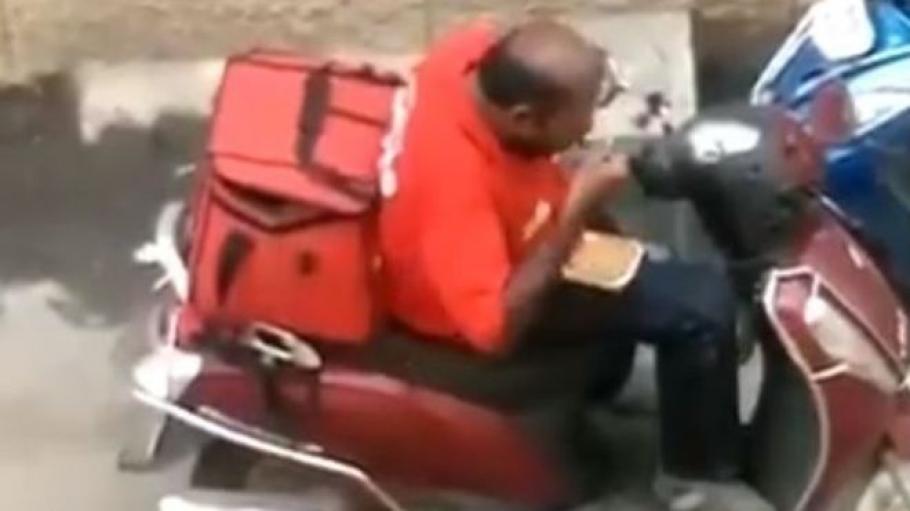 Bărbatul filmat mâncând Bărbatul filmat în timp ce mănâncă din mâncarea pe care o livrează
