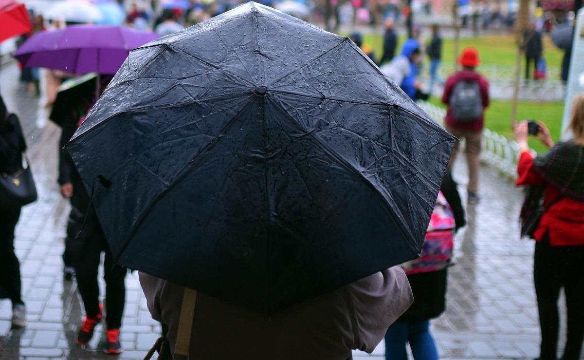 Femeie ține umbrela pe o vreme ploioasă