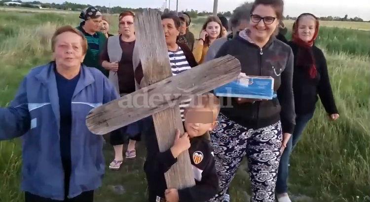 Imagini şocante în Bărăgan! Copil pus să care o cruce luată din cimitir, într-un ritual de invocare a ploii (Video)