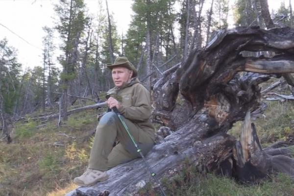 Vladimir Putin se odihnește pe un trunchi de copac, în Siberia