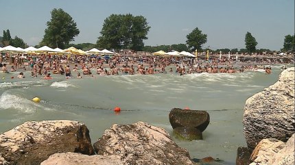 Turişti pe plajă şi în mare pe o vreme însorită, în staţiunea Neptun