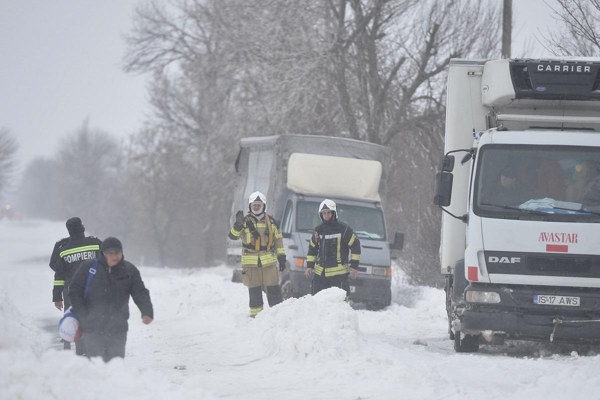 Echipe de intervenție pe un drum blocat de ninsoare