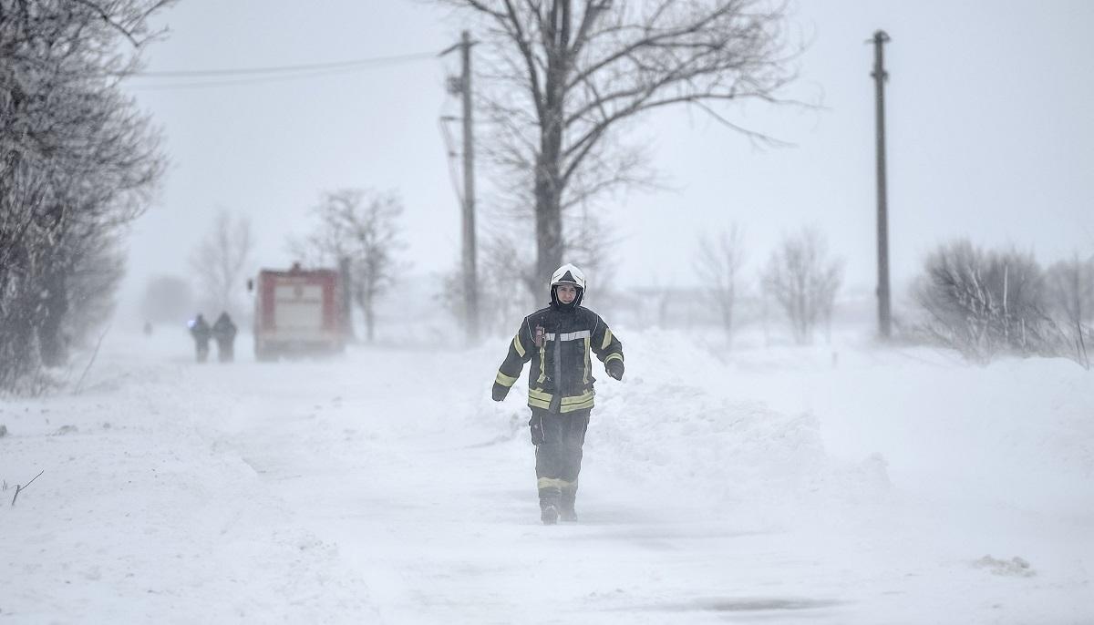 Pompier pe o șosea înzăpezită, în timpul iernii