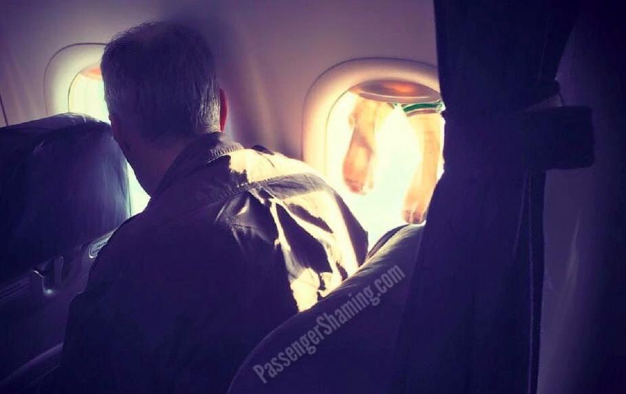 Șosete pe hubloul unui avion Pasager pozat în timp ce-și usucă șosetele pe geamul avionului