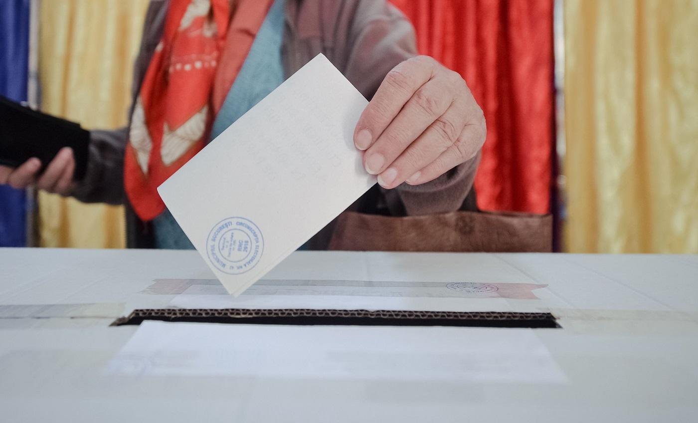 Alegătoare pune buletinul de vot în urnă