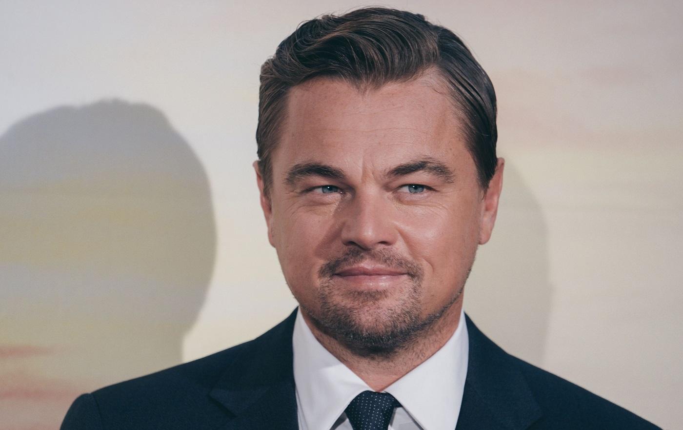 Leonardo DiCaprio zâmbește presei la o ceremonie