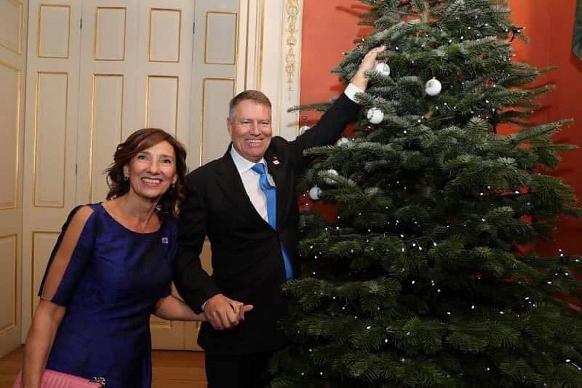 Carmen și Klaus Iohannis Carmen și Klaus Iohannis zâmbesc lângă bradul de Crăciun de la Palatul Buckingham