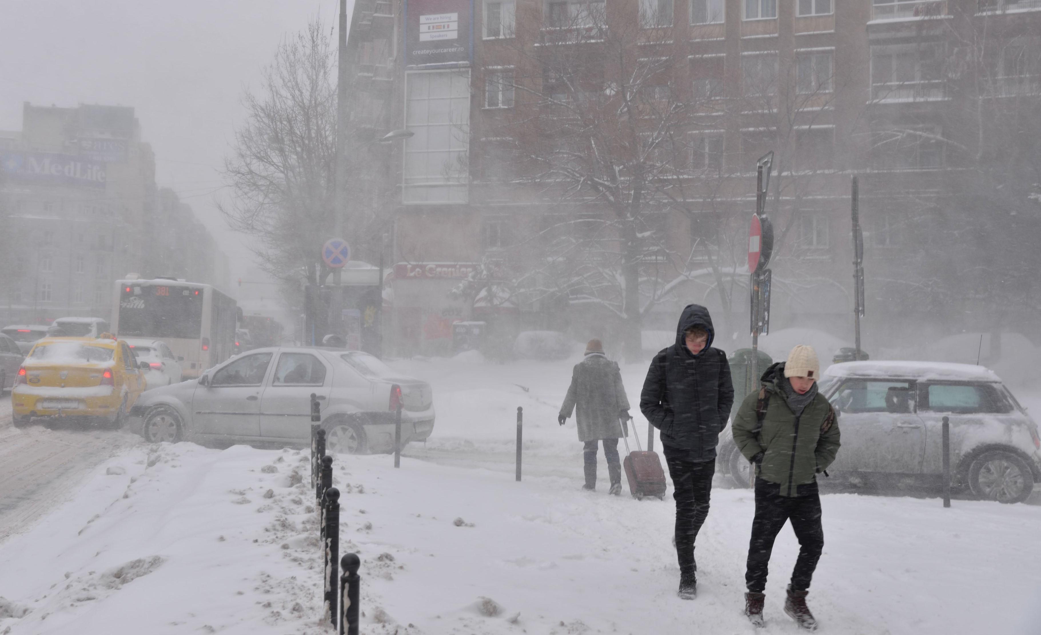 Oameni în zăpadă pe o stradă din Bucureşti