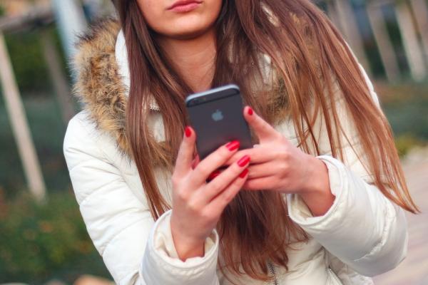 Femeie se uită la un telefon