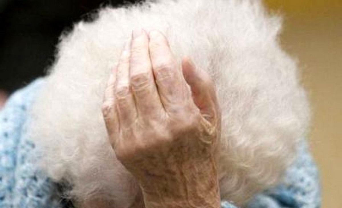Bătrână Bătrână care plânge își ține capul în mâini