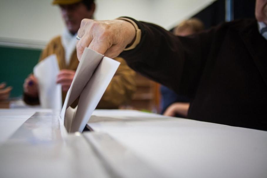 Alegeri locale 2020 O persoană introduce un vot în urnă