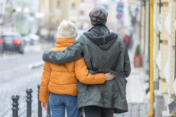Tineri care merg îmbrăţişaţi pe stradă