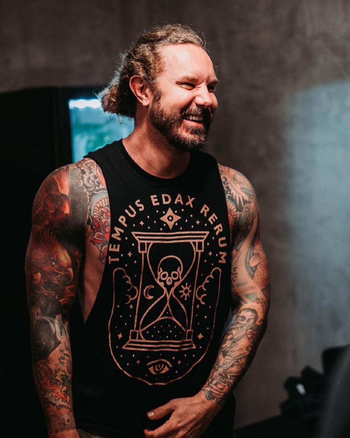 Tim Lambesis purtând un maiou negru, cu tatuajele la vedere, în timpul unui concert