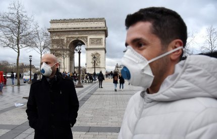 Turiști cu măști la Arcul de Triumf din Paris