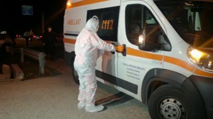 Medic în combinezon urcă într-o ambulanță