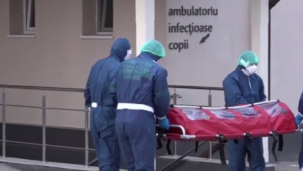 Medici transportă un copil cu coronavirus în izoletă