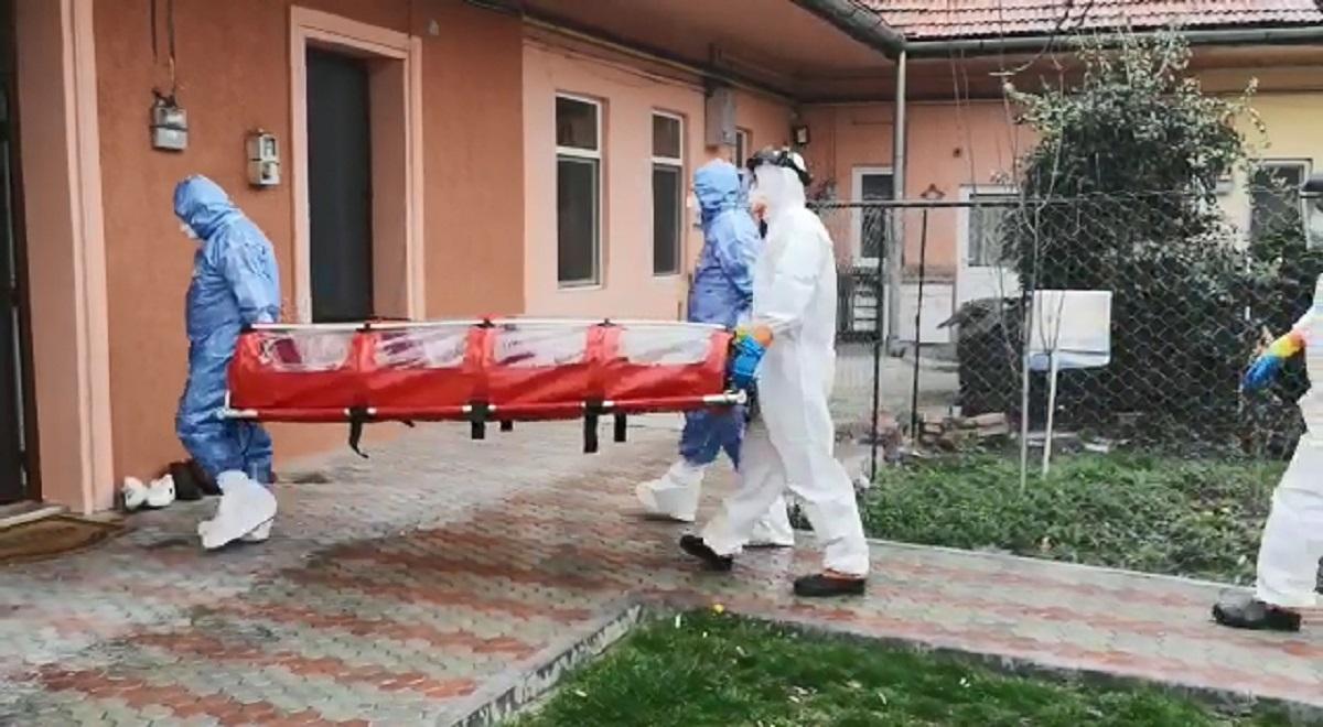 Medici în costum de protecţie merg cu izoleta la un bolnav de coronavirus