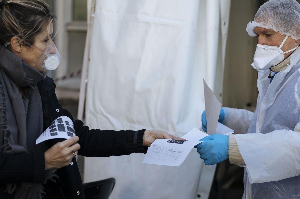 Coronavirus România Un medic cu mască de protecție oferă analizele unei femei