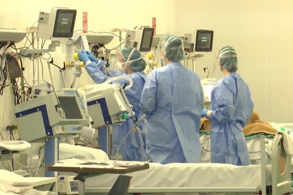 Medici italieni lângă un pat de spital cu pacient cu coronavirus