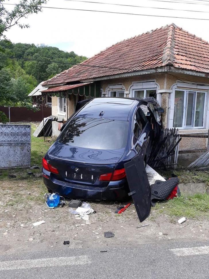 Una dintre mașini a ajuns cu roțile pe pereții unei case de la marginea drumului