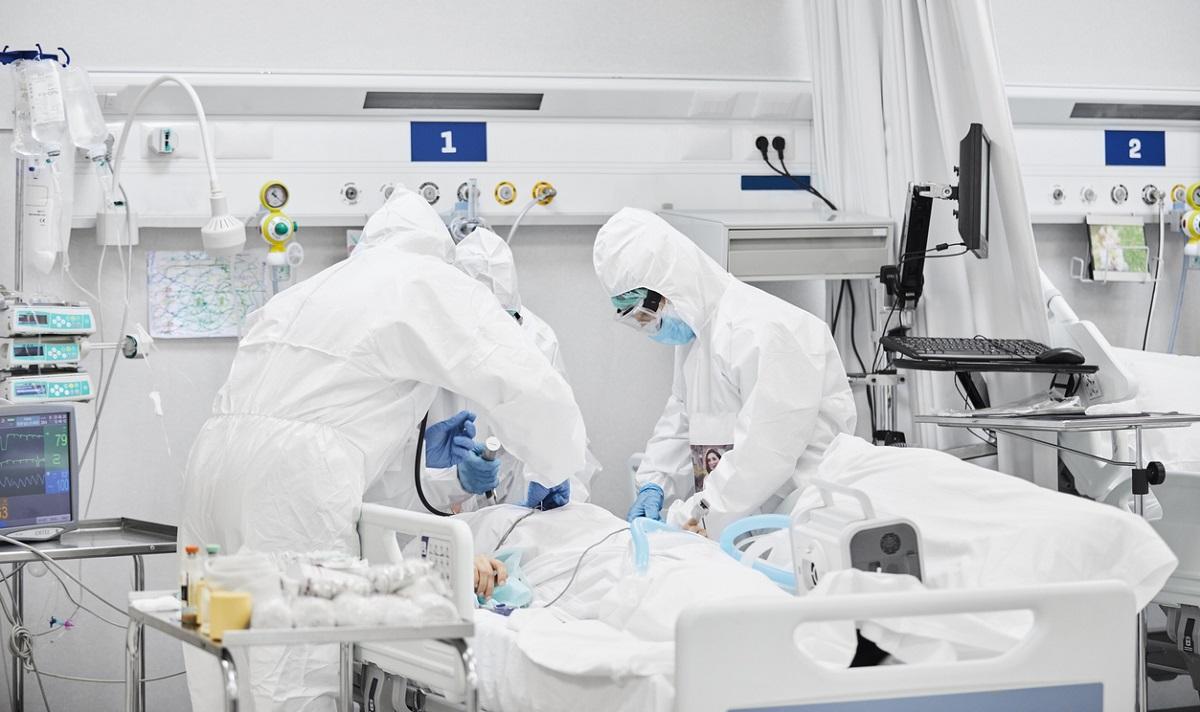 Medici în combinezoane Medici în combinezoane tratează pacient pe patul de spital