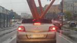 Imagini virale. Craiovean, filmat în timp ce transporta cu un Renault Megane decapotabil mai multe țevi, pe ploaie