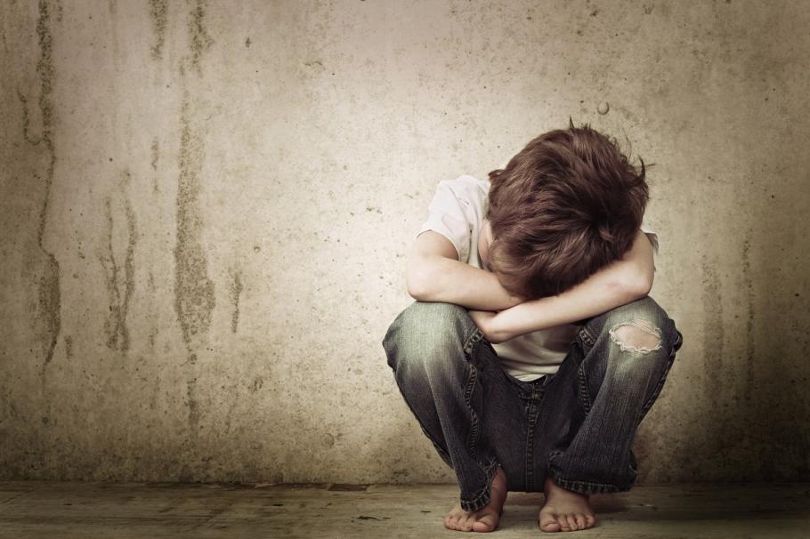 Copil neîngrijit Băiat care stă cu faţa ascunsă; violenţă domestică