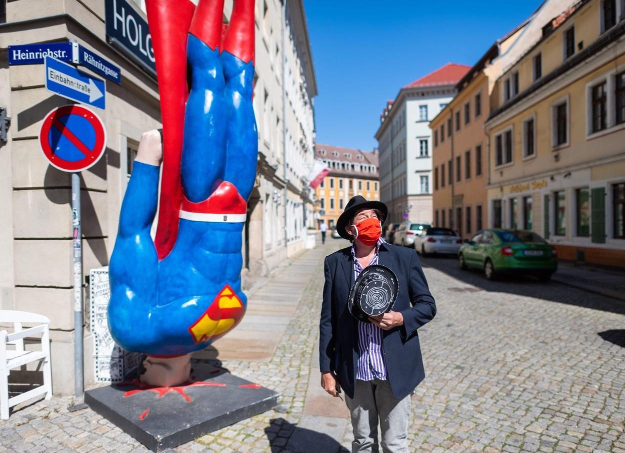 Artistul Holger stă în faţa galeriei sale din Dresda alături de statuia lui Superman realizată de Marcus Witwers