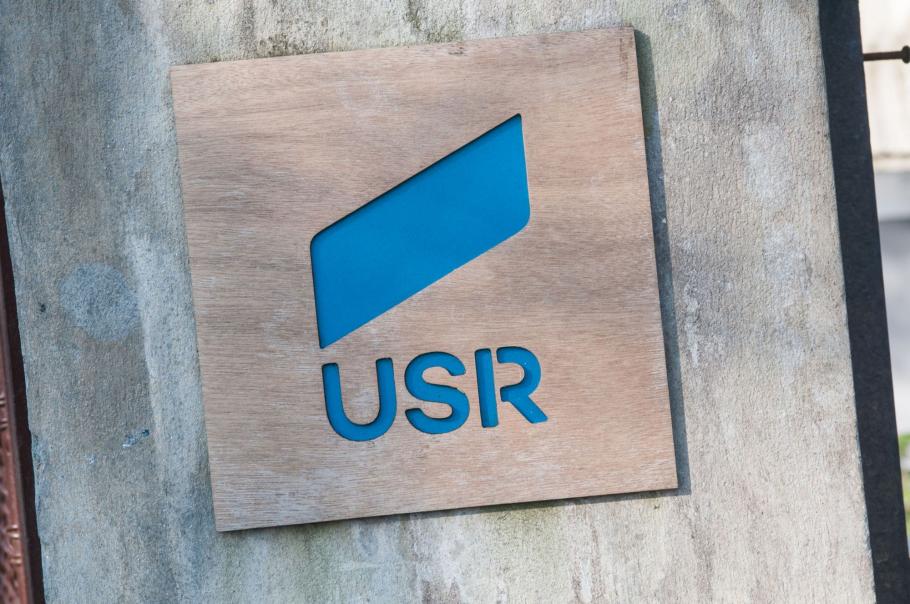 USR vrea ca certificatul verde să fie obligatoriu pentru toţi angajaţii, iar salariaţii să suporte costurile testărilor periodice Sigla USR pe un perete gri