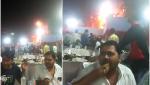 Doi invitați la o nuntă din India rămân la masă și continuă să mănânce liniștiți, în timp ce un foc uriaș arde tot în spatele lor