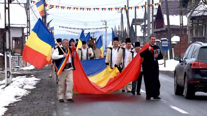 On Romania's National Day, dozens of Maramures residents wore festive clothes and laid a 24-meter flag at the Heroes' Monument