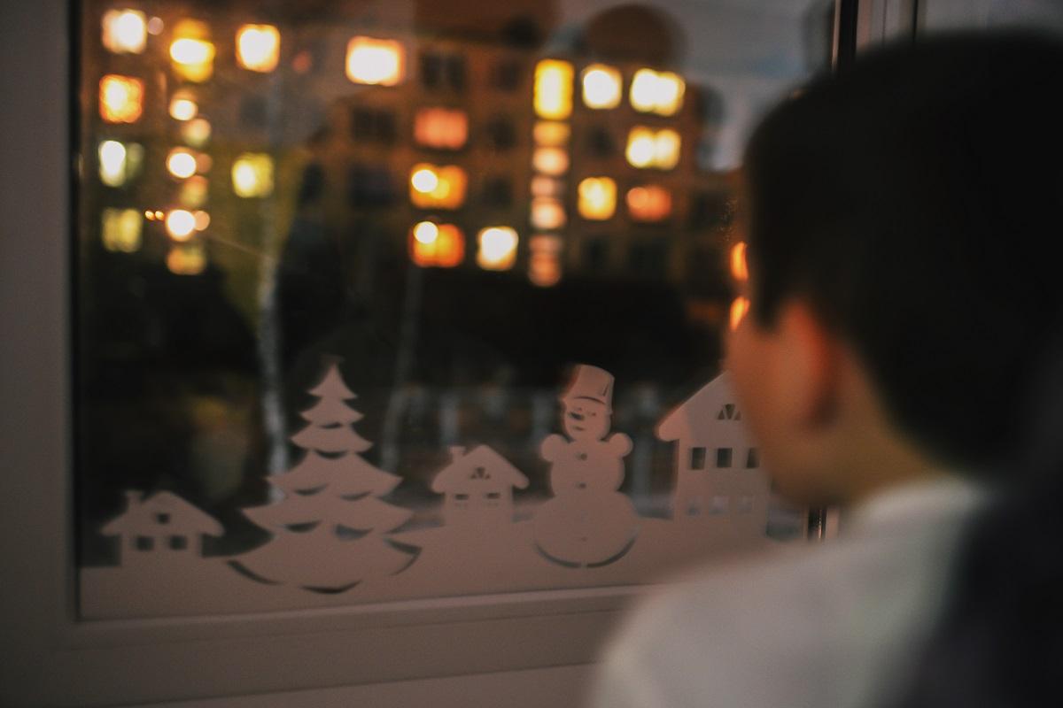 Băiat care se uită pe geam