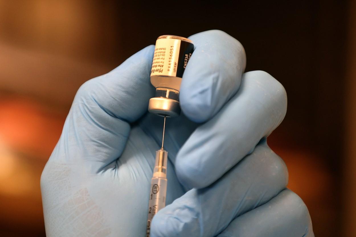 Un medic prepară seringa cu un vaccin Pfizer