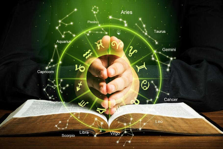 Horoscop 24 februarie 2021. Semne zodiacale pe un fundal cu o carte şi două mâini împreunate