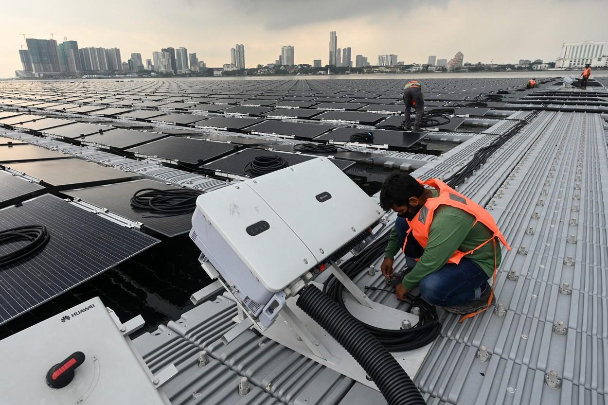 Un muncitor face reglaje la panourile solare amplasate pe mare, în Singapore