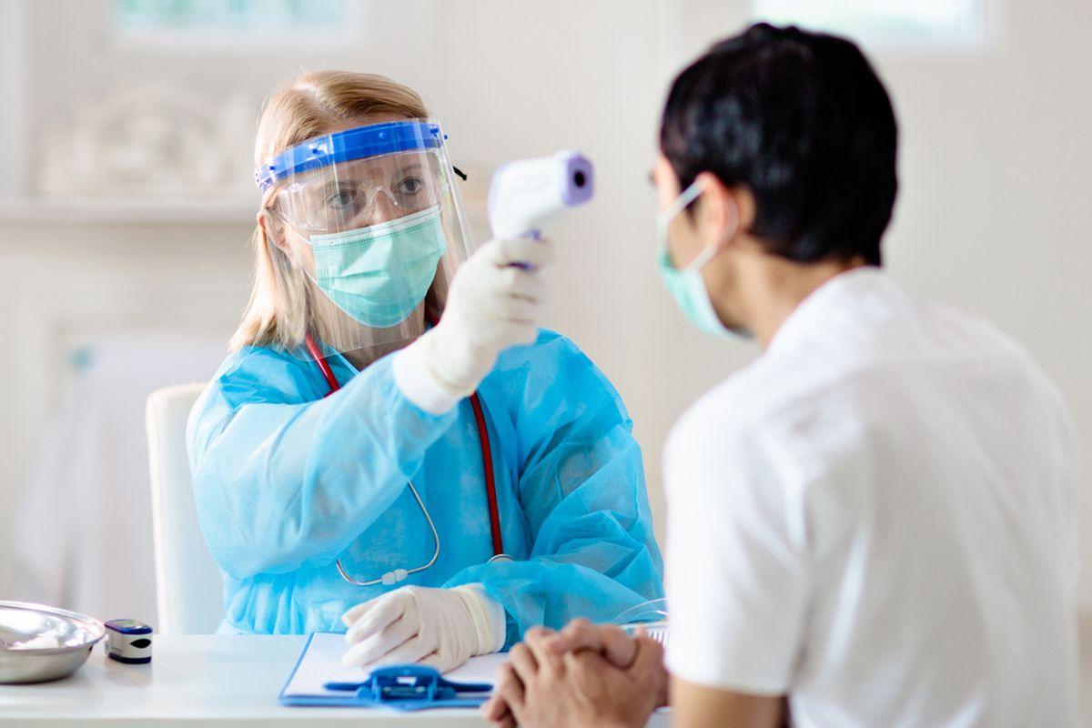 Un doctor examinează un pacient suspect de coronavirus