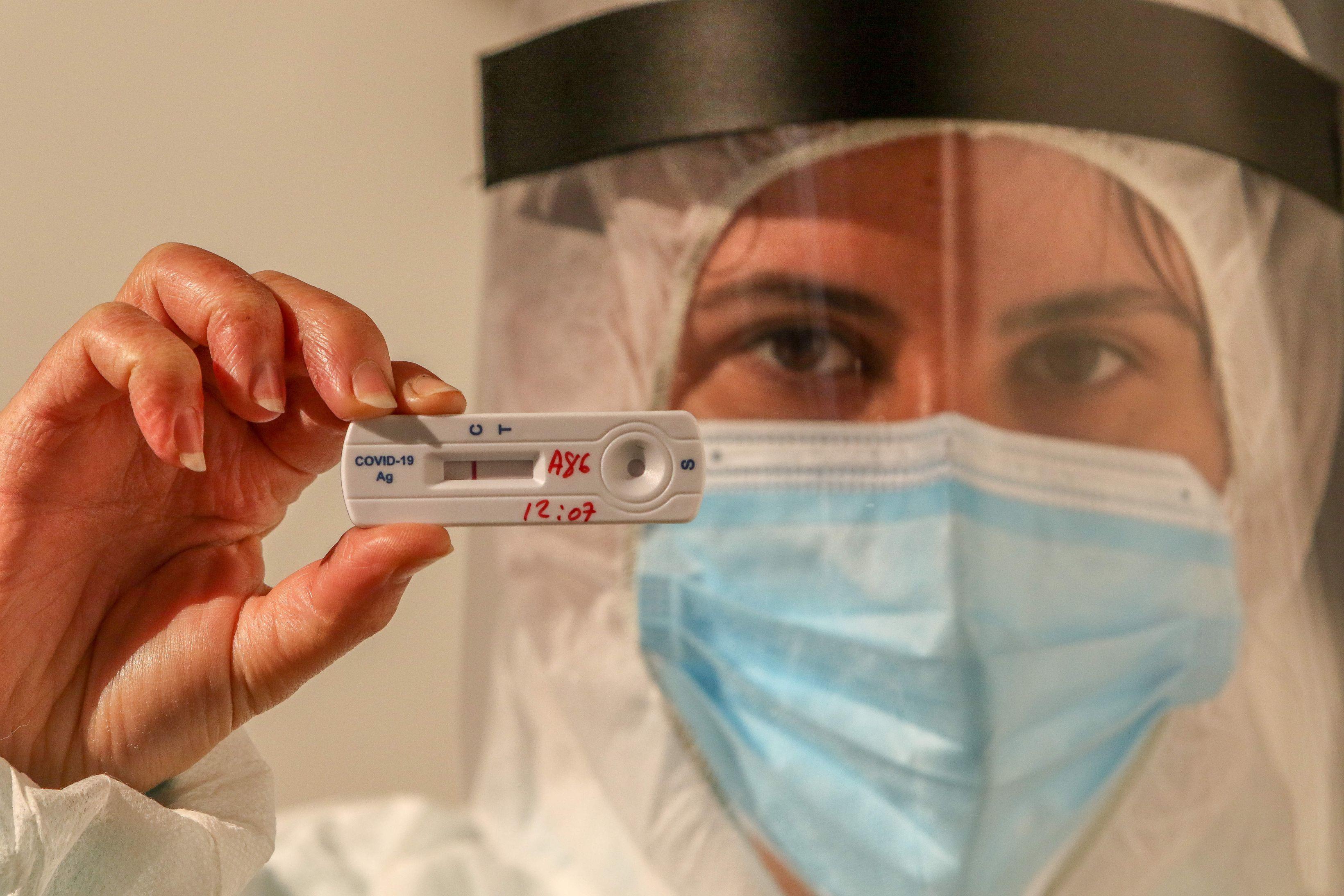 O asistentă ține un test rapid de detectare a coronavirusului