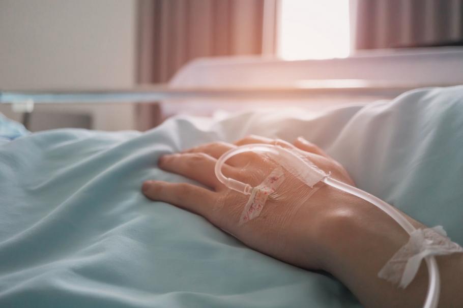 Persoană pe patul de spital Persoană pe patul de spital cu perfuzie în mână