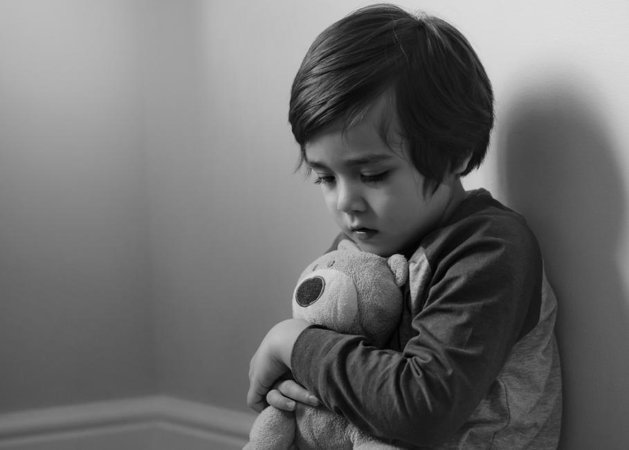 Băieţel Băieţel trist cu un ursuleţ în mână