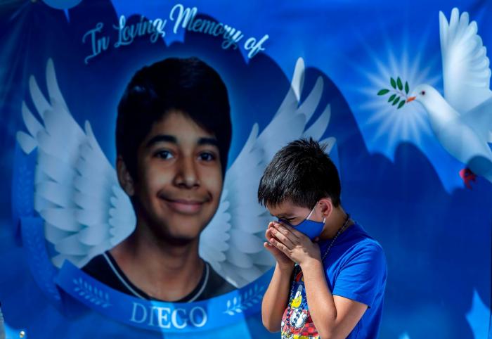 Eric Henry, în vârstă de 9 ani, din Moreno Valley se roagă în timpul memorialului în parcarea școlii gimnaziale Landmark, pentru a comemora moartea lui Diego Stolz