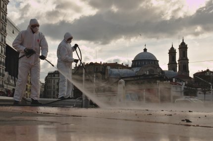 Doi muncitori din Istanbul dezinfectează