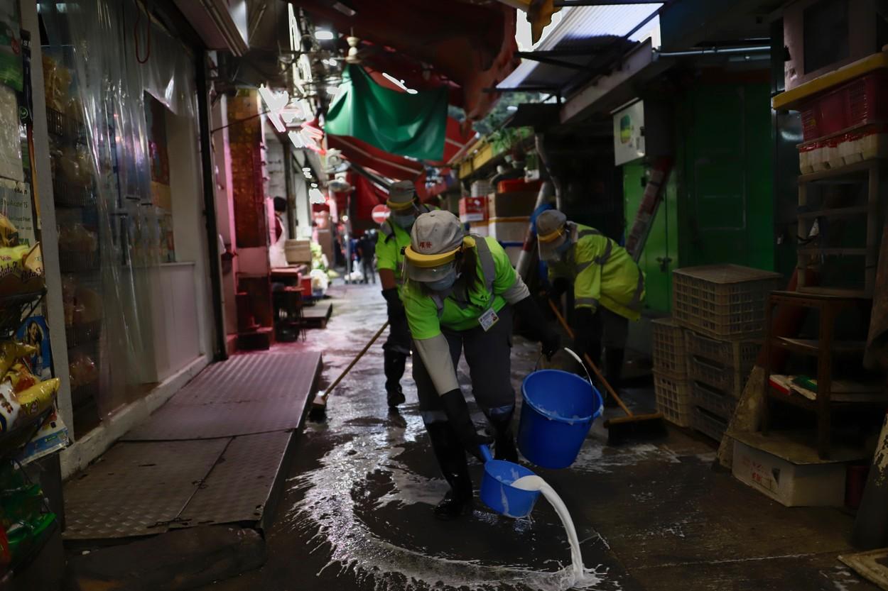 Fotografie dintr-o piață din China. Muncitorii dezinfectează zona Fotografie dintr-o piață din China. Muncitorii dezinfectează zona