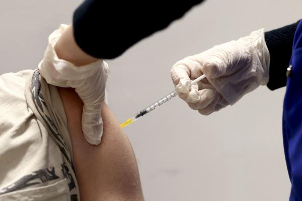 O persoană este vaccinată cu vaccinul împotriva Covid-19