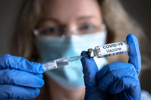 O doză de vaccin în mâinile unui cercetător