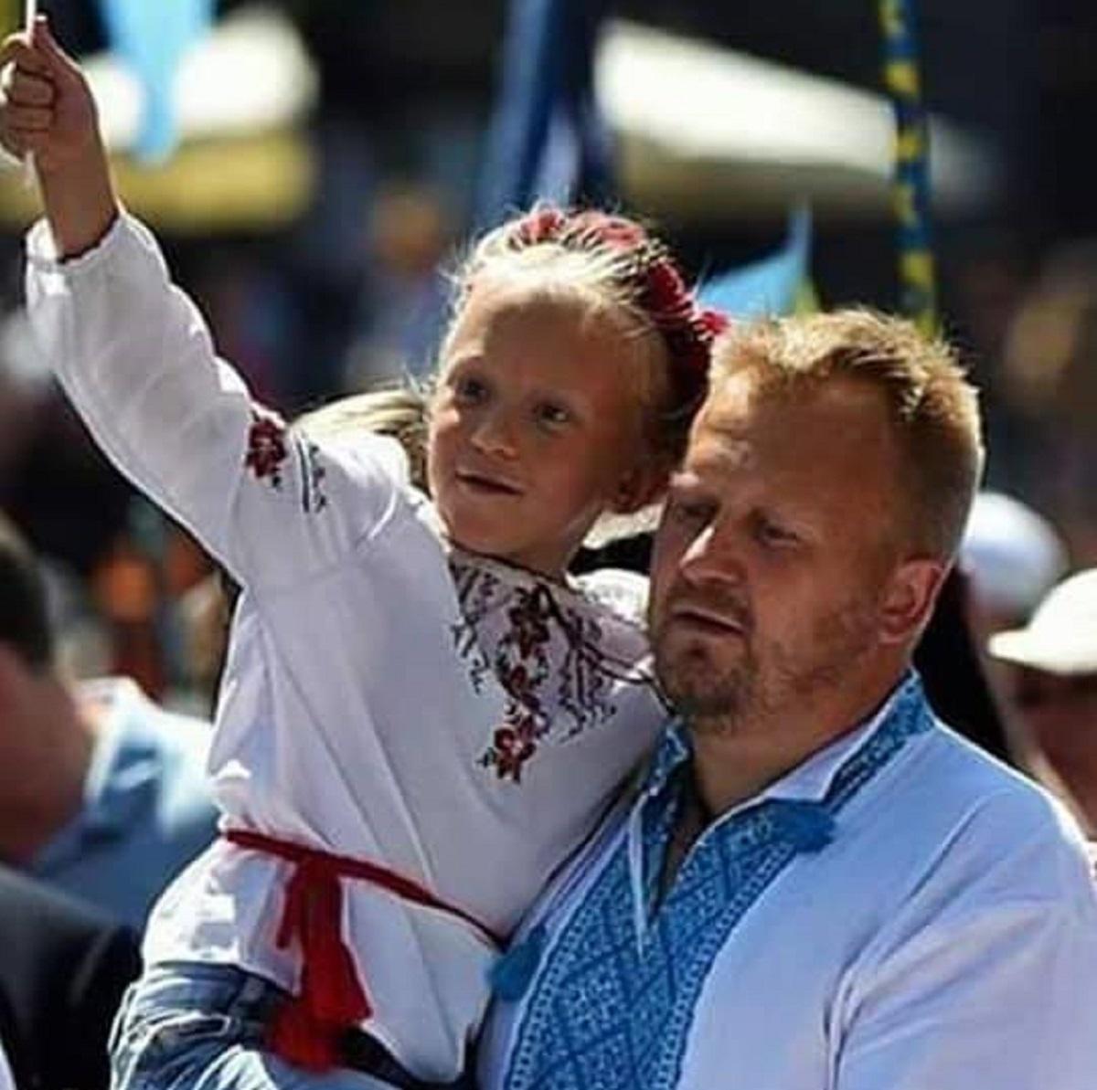 Tatăl şi una dintre fiice, îmbrăcaţi în costume populare