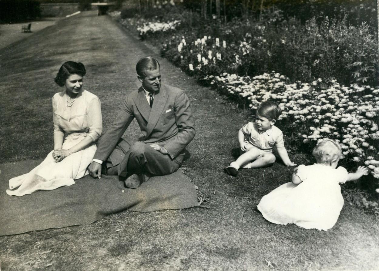Prințesa Elisabeta (stânga), în grădina de la Clarence House, cu soțul ei Ducele de Edinburgh și doi dintre cei patru copii ai cuplului, Prințul Charles și Prințesa Anna, în 1951