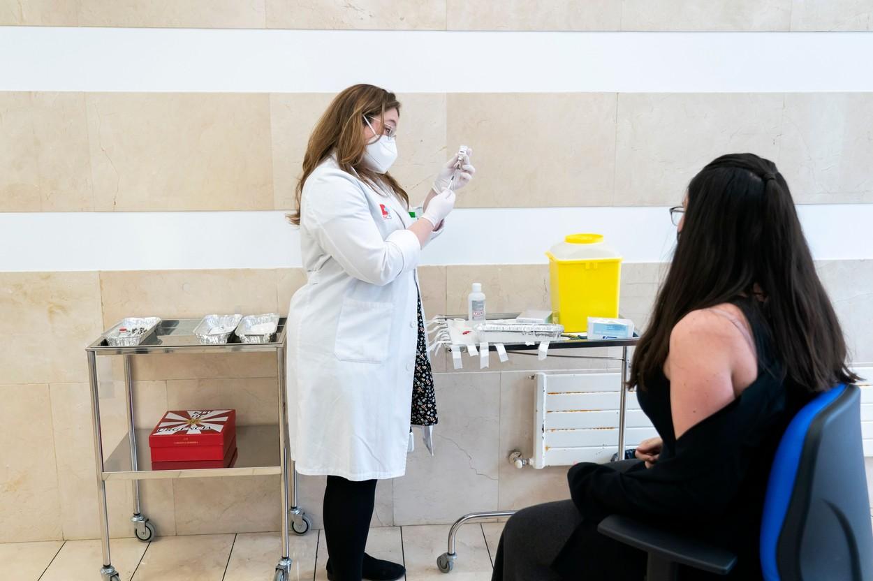 O tânără așteaptă să fie vaccinată O tânără așteaptă să fie vaccinată