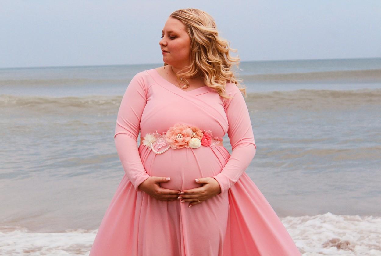 Kristan Othersen, îmbrăcată într-o rochie de culoare roz, pe plajă