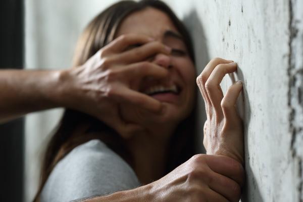 În imagine: Tânără împinsă la perete, sugerând agresiune