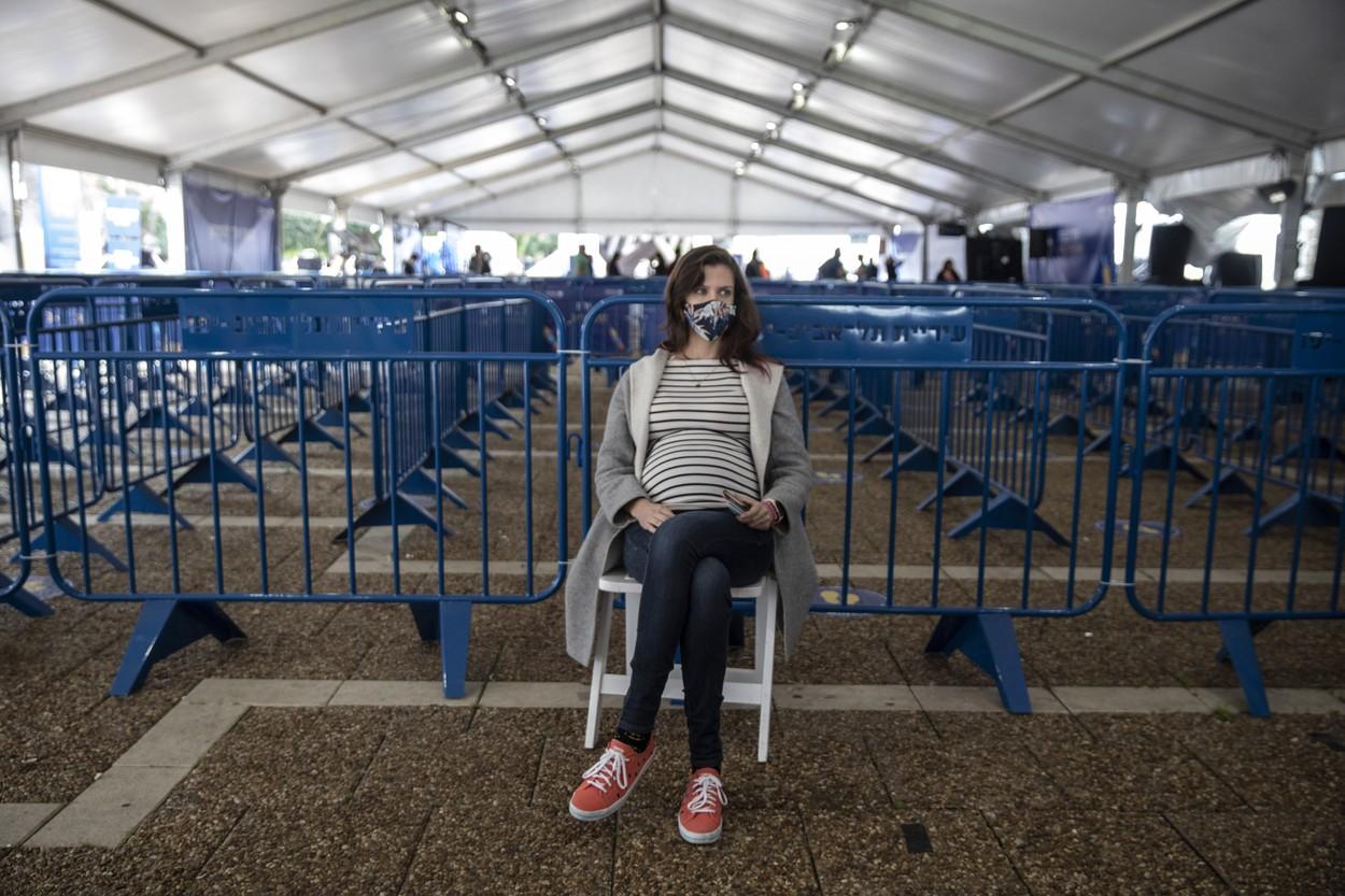 Shira Weinberg ,36, eight months pregnant, rests after receiving the Pfizer-BioNTech coronavirus vaccine at a COVID-19